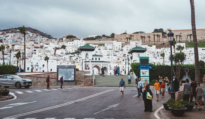 Bustling street in Tétouan with traditional Moroccan architecture and lively atmosphere.