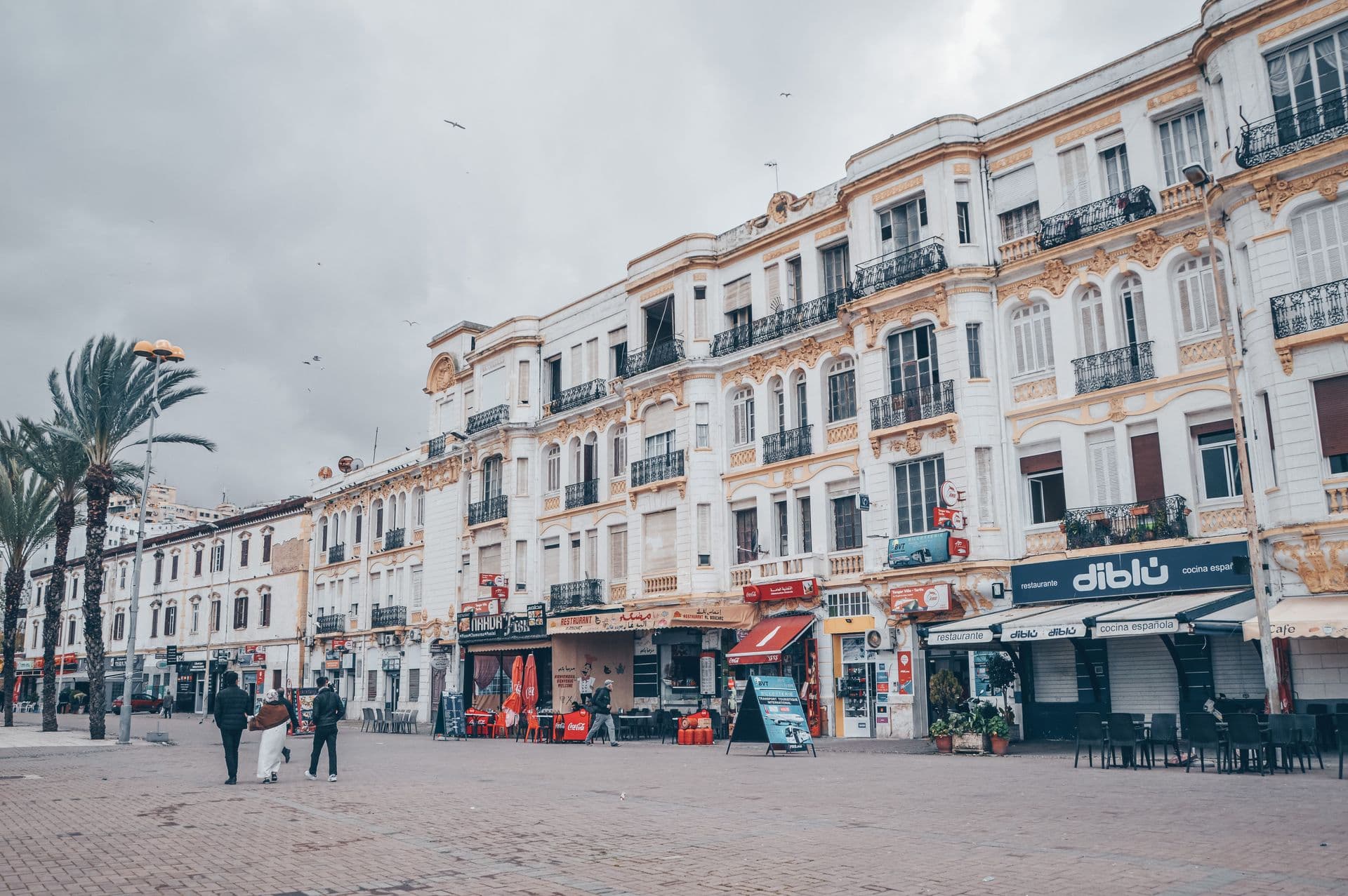Elegant colonial buildings line a bustling city square in Tangier, Morocco.