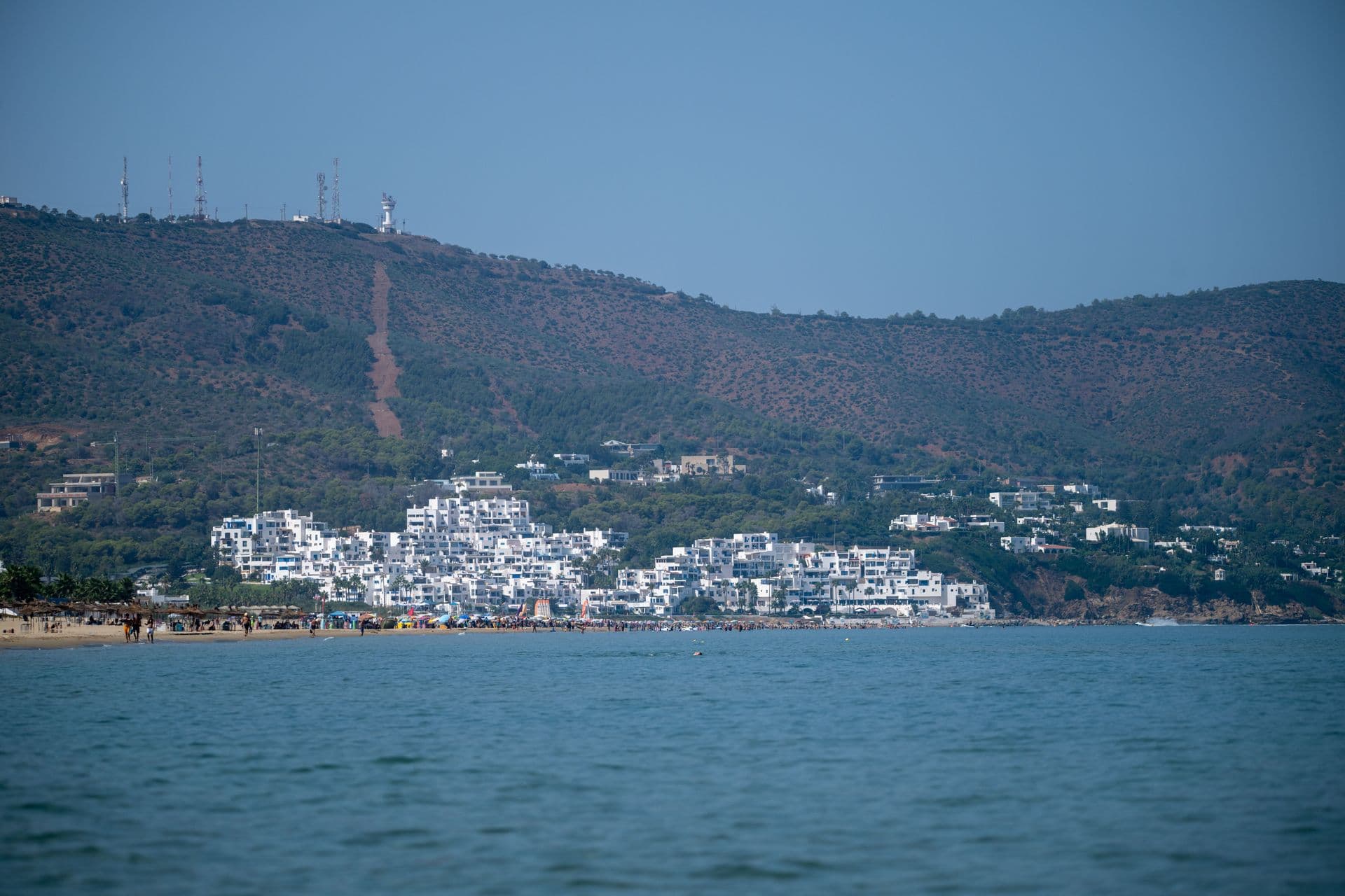 Breathtaking coastal view with white buildings and lush hills in Tétouan, Morocco.